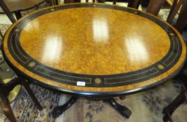 A Victorian ebonised and amboyna and inlaid breakfast table in the manner of Holland & Sons, the