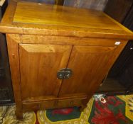 A Chinese elm two door cupboard enclosing shelf with two drawers below,