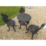 A black painted cast iron table and three matching chairs