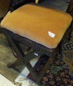 A Victorian carved walnut X-framed stool with upholstered drop-in seat on lions paw feet