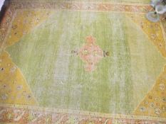 A Turkish rug, the central panel with a stylised lozenge shaped medallion on a green ground,