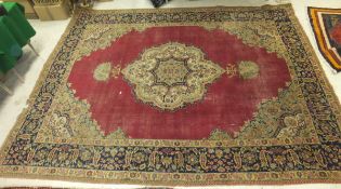 A Persian carpet, the central floral decorated medallion in cream, pale blue, dark blue,