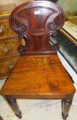 An early 19th Century mahogany panel seated hall chair with C-scroll and cornucopia carved back,