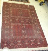 A Beluche style rug, with two square panels on a dark red ground,