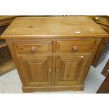 A modern pine dresser with two drawers over two panelled doors on bracket feet