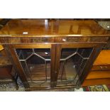 A reproduction mahogany glazed two door book case with adjustable shelves,