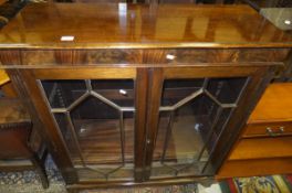 A reproduction mahogany glazed two door book case with adjustable shelves,