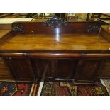 A Victorian mahogany sideboard with raised back over a plain top,