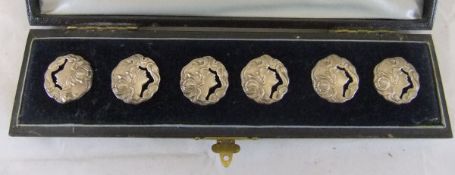 A cased set of six silver Art Nouveau style buttons depicting a girl's head with flowers in her