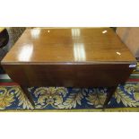 An early 19th Century mahogany drop leaf Pembroke table on square tapered legs to brass caps and