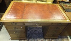 An oak kneehole desk, the tooled and gilded leather insert top above central drawer flanked by two