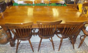A modern oak refectory style dining table, and a set of eight stick back kitchen chairs with