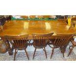 A modern oak refectory style dining table, and a set of eight stick back kitchen chairs with