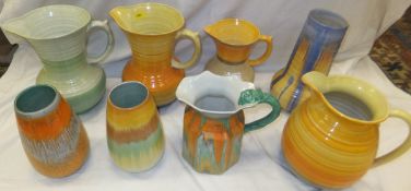 A collection of Shelley pottery jugs and vases, to include four jugs with concentric circle