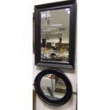 A modern rectangular black framed wall mirror,