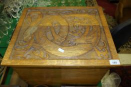 A 20th Century oak carved box decorated with a dragon in the Arts & Crafts taste