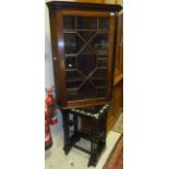 A mahogany wall hanging corner display unit with astragal glazed door enclosing four shelves,