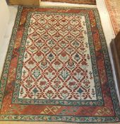 A Caucasian rug, the centre field with stylised floral motifs in terracotta, teal blue and pale gold