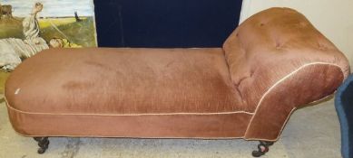 A Victorian chaise longue with salmon pink upholstery on ringed and turned supports to china