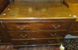 A mahogany chest of three drawers with brass handles, with brushing slide above,