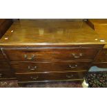 A mahogany chest of three drawers with brass handles, with brushing slide above,