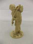 A Meiji period Japanese carved ivory okimono of an elderly gentleman carrying a stick and basket and