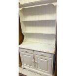 A white painted dresser with plate rack over two drawers and two cupboard doors,