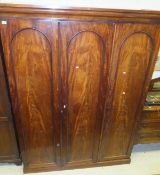 A mahogany three door wardrobe, the right hand door with hanging space, with moulded cornice,