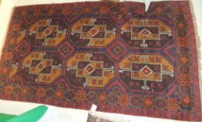 A Bokhara rug, the six central elephant foot medallions in aubergine, mustard, red and cream,