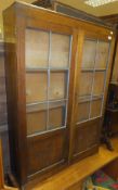 An early 20th Century oak glazed book case cabinet