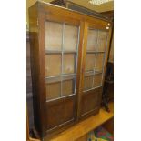 An early 20th Century oak glazed book case cabinet