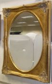 A rectangular gilt decorated wall mirror with oval plate