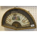 A framed French fan decorated with ladies in a landscape