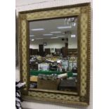 A rectangular wall mirror with cream and gilt decorated frame