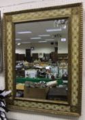 A rectangular wall mirror with cream and gilt decorated frame