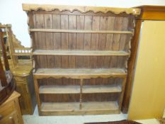 A waxed pine dresser of five open shelves with boarded back