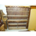 A waxed pine dresser of five open shelves with boarded back