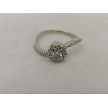 A 14ct white gold diamond set cluster ring with diamond chips to shoulders