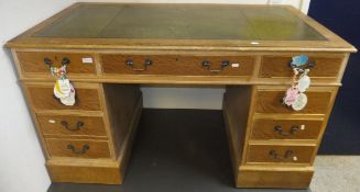 A limed oak kneehole desk, the tooled and gilded leather insert top above a central drawer flanked