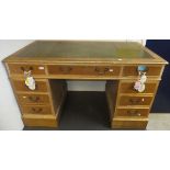 A limed oak kneehole desk, the tooled and gilded leather insert top above a central drawer flanked