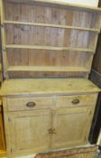 A circa 1900 pine dresser with three tier plate rack over two drawers and two cupboard doors