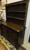 A modern oak dresser in the Old Charm manner with two tier boarded plate rack over two drawers and