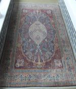 A Persian rug, the central panel with "Tree of Life" decoration in cream, pale gold, pale blue, iron