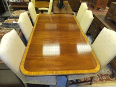 A Brights of Nettlebed Sheraton style mahogany and cross banded dining table on pillar supports to