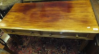 A Victorian mahogany two drawer side table on turned and reeded tapering legs to brass caps and