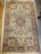 A Persian silk rug, the central floral decorated medallion in terracotta, cream,