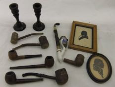 A box containing assorted smoker's pipes, two silhouettes of gentlemen,