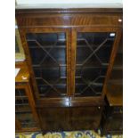 A reproduction mahogany and inlaid bookcase cabinet, the two glazed doors enclosing shelving,