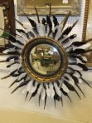 A Regency style circular giltwood convex wall mirror with later feather embellishments