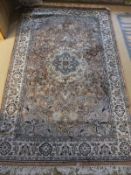 A Persian rug, the central panel with floral decoration on salmon pink ground,